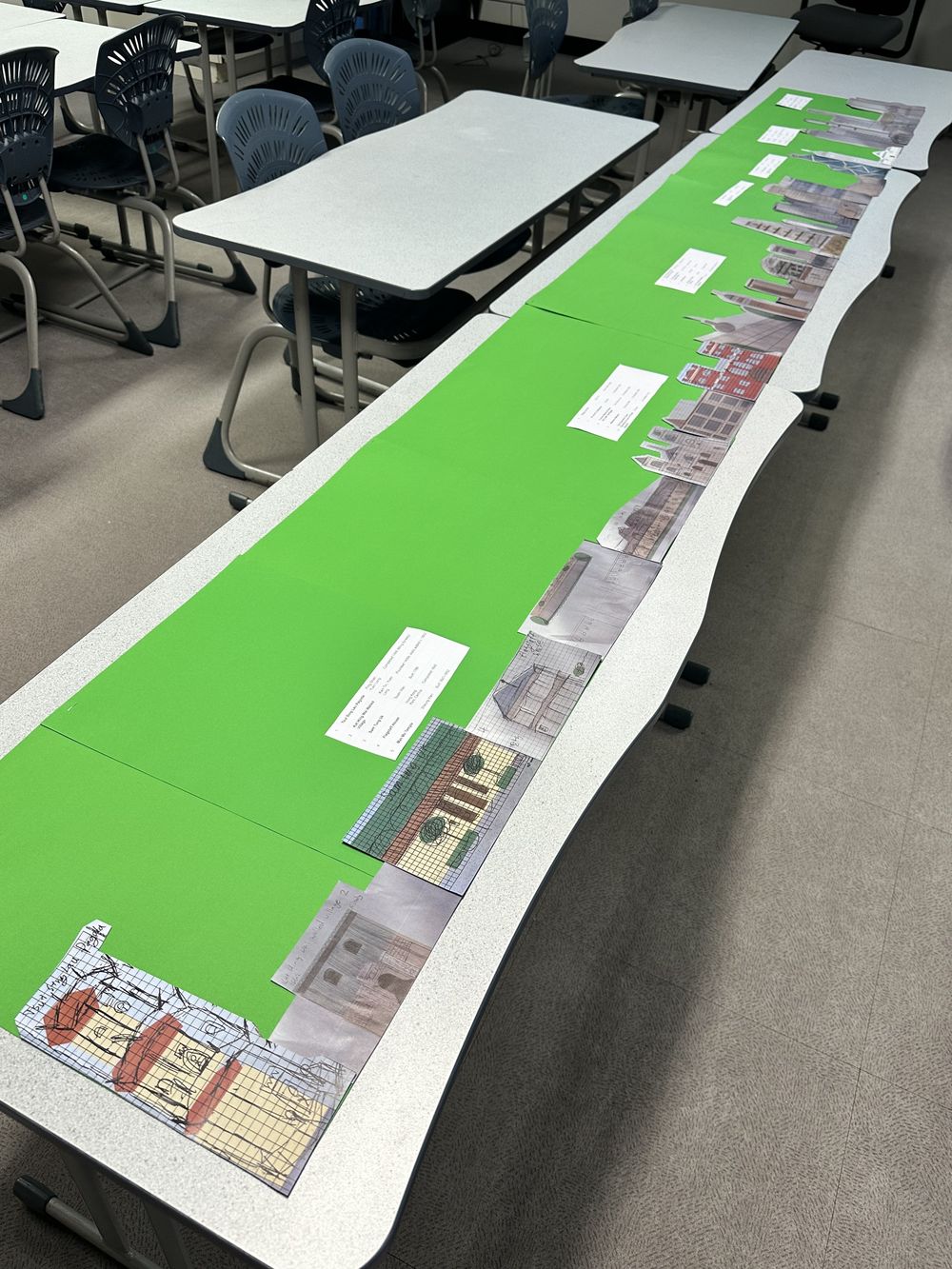 The mounted cut-outs laid out in date order along green card on classroom desks